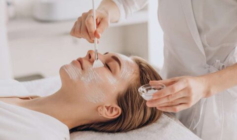 cosmetologa-haciendo-tratamiento-facial-aplicando-mascarilla