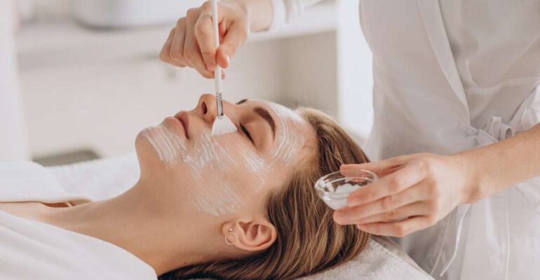 cosmetologa-haciendo-tratamiento-facial-aplicando-mascarilla