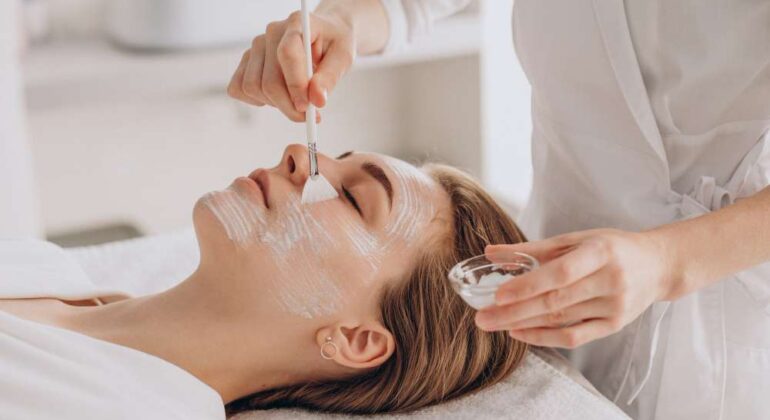 cosmetologa-haciendo-tratamiento-facial-aplicando-mascarilla